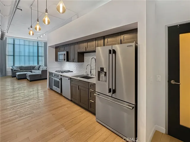 a kitchen with stainless steel appliances a refrigerator sink and cabinets