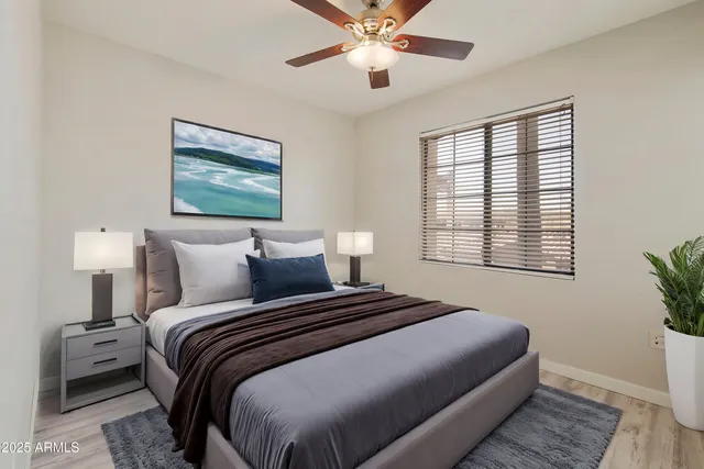 a bedroom with a large bed a chandelier and windows