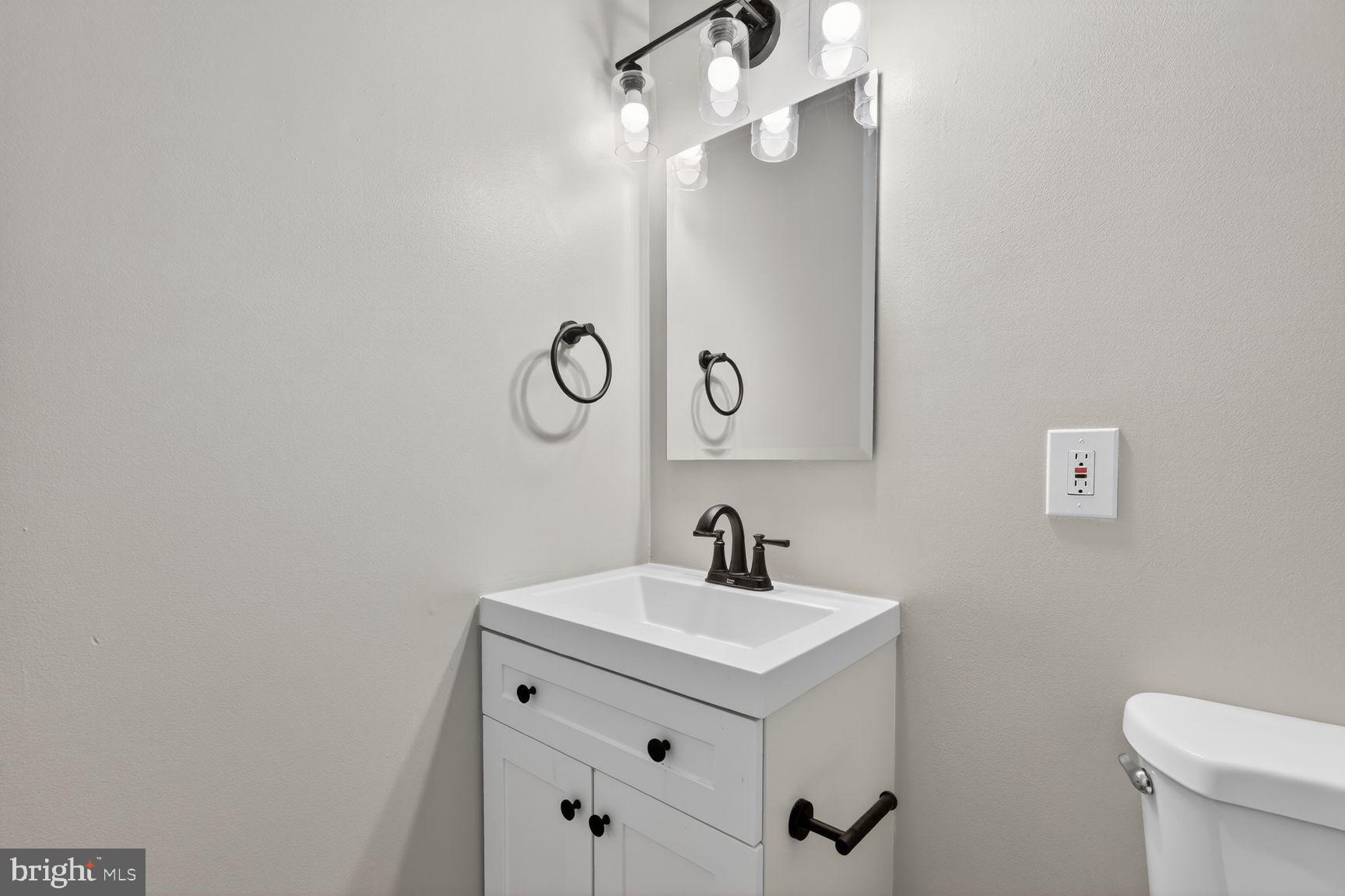1008 Rittenhouse Street Northwest, Unit 15 Washington, DC 20011 - Photo 7 of 39 a bathroom with a sink a toilet and mirror