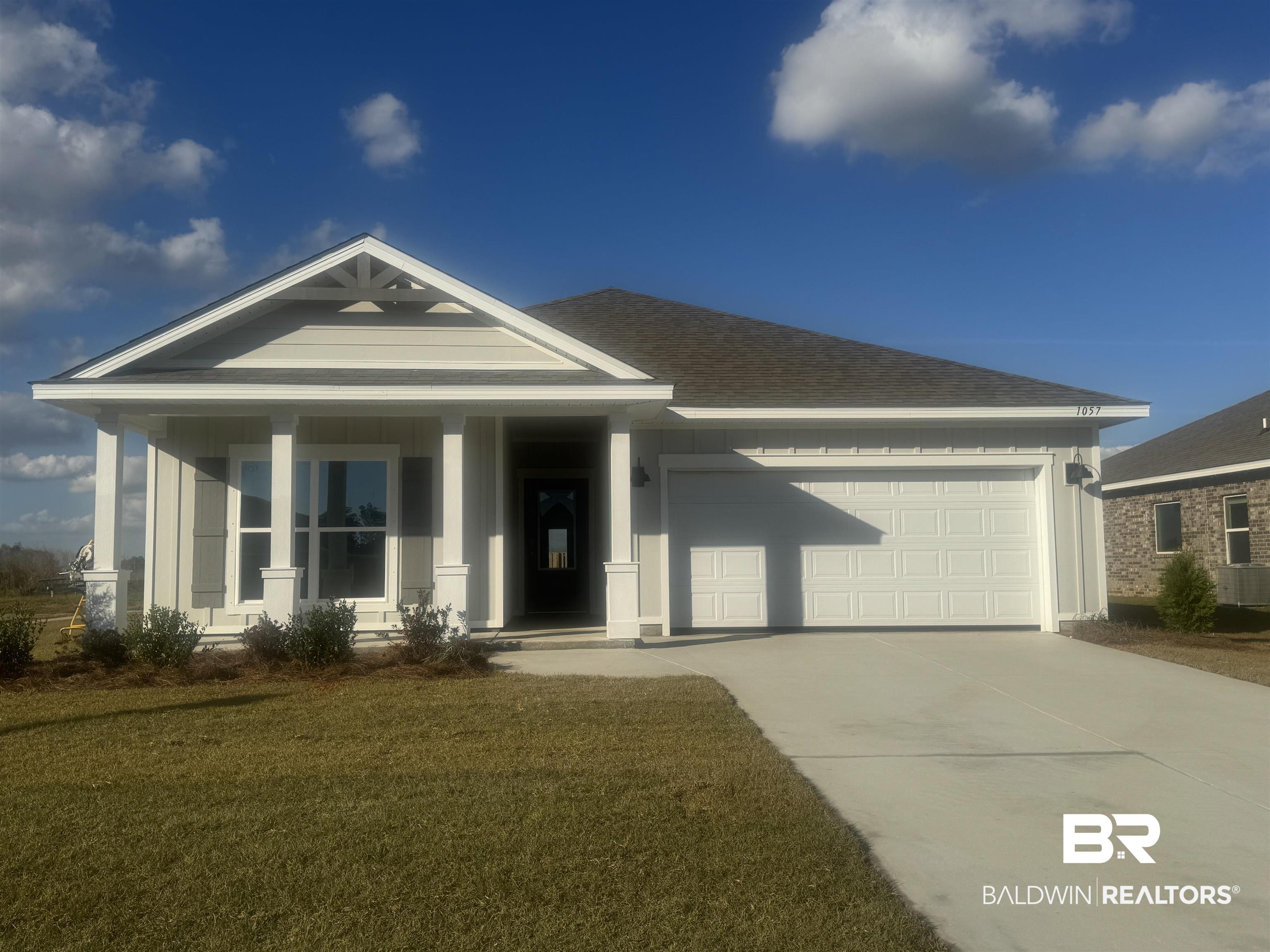 1057 Hayward Loop Foley, AL 36535 - Photo 1 of 35 View of front facade with covered porch, a front yard, concrete driveway, an attached garage, and roof with shingles