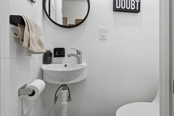 a bathroom with a sink mirror and toilet