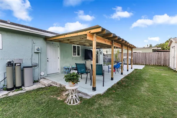 a view of a backyard with table and chairs and a barbeque