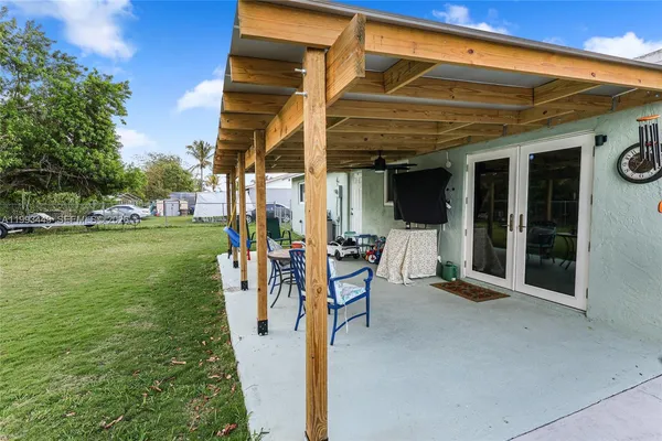 a view of a patio with a table and chairs and potted plants