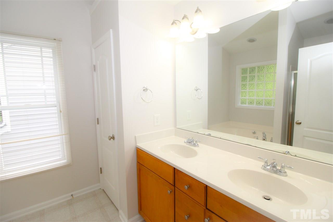 3313 Sunbright Lane Raleigh, NC 27610 - Photo 13 of 25 a bathroom with a sink a mirror and a shower