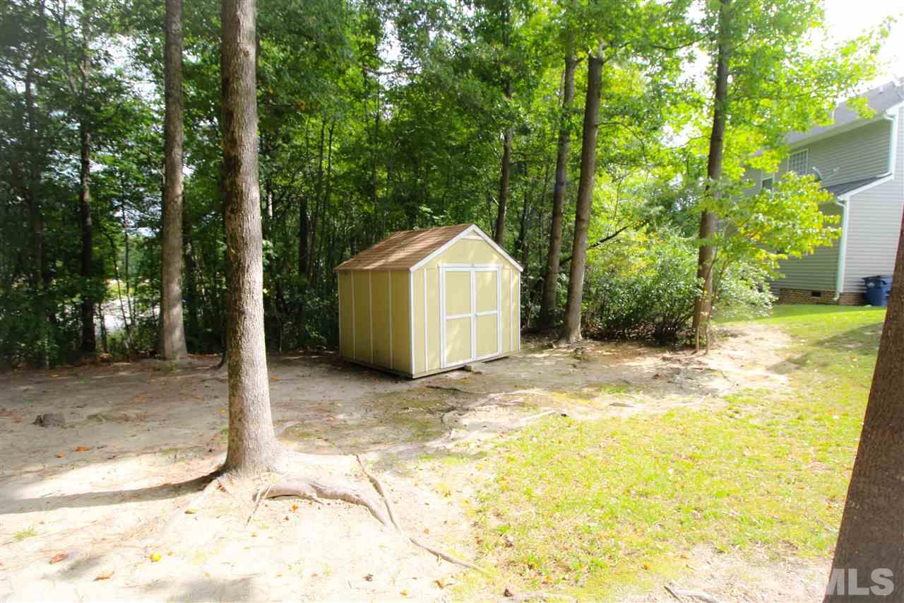 3313 Sunbright Lane Raleigh, NC 27610 - Photo 24 of 25 a view of a backyard with large tree and wooden fence