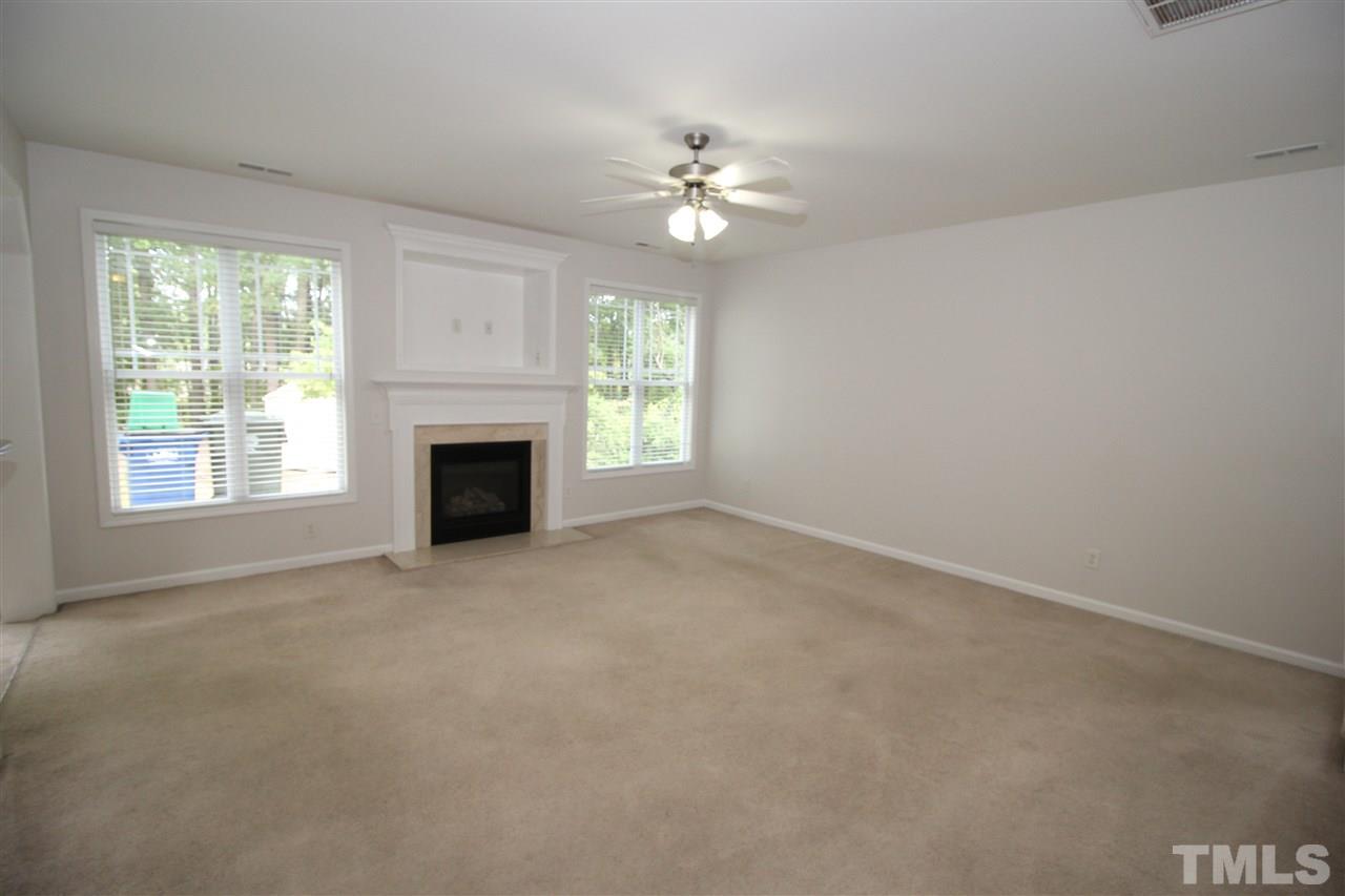 3313 Sunbright Lane Raleigh, NC 27610 - Photo 5 of 25 a view of a livingroom with a fireplace and chandelier fan