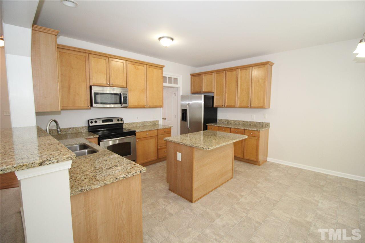 3313 Sunbright Lane Raleigh, NC 27610 - Photo 7 of 25 a kitchen with stainless steel appliances granite countertop a stove a sink a microwave a refrigerator a counter space and cabinets