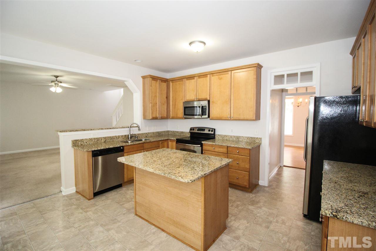 3313 Sunbright Lane Raleigh, NC 27610 - Photo 8 of 25 a kitchen with stainless steel appliances granite countertop a sink stove and refrigerator