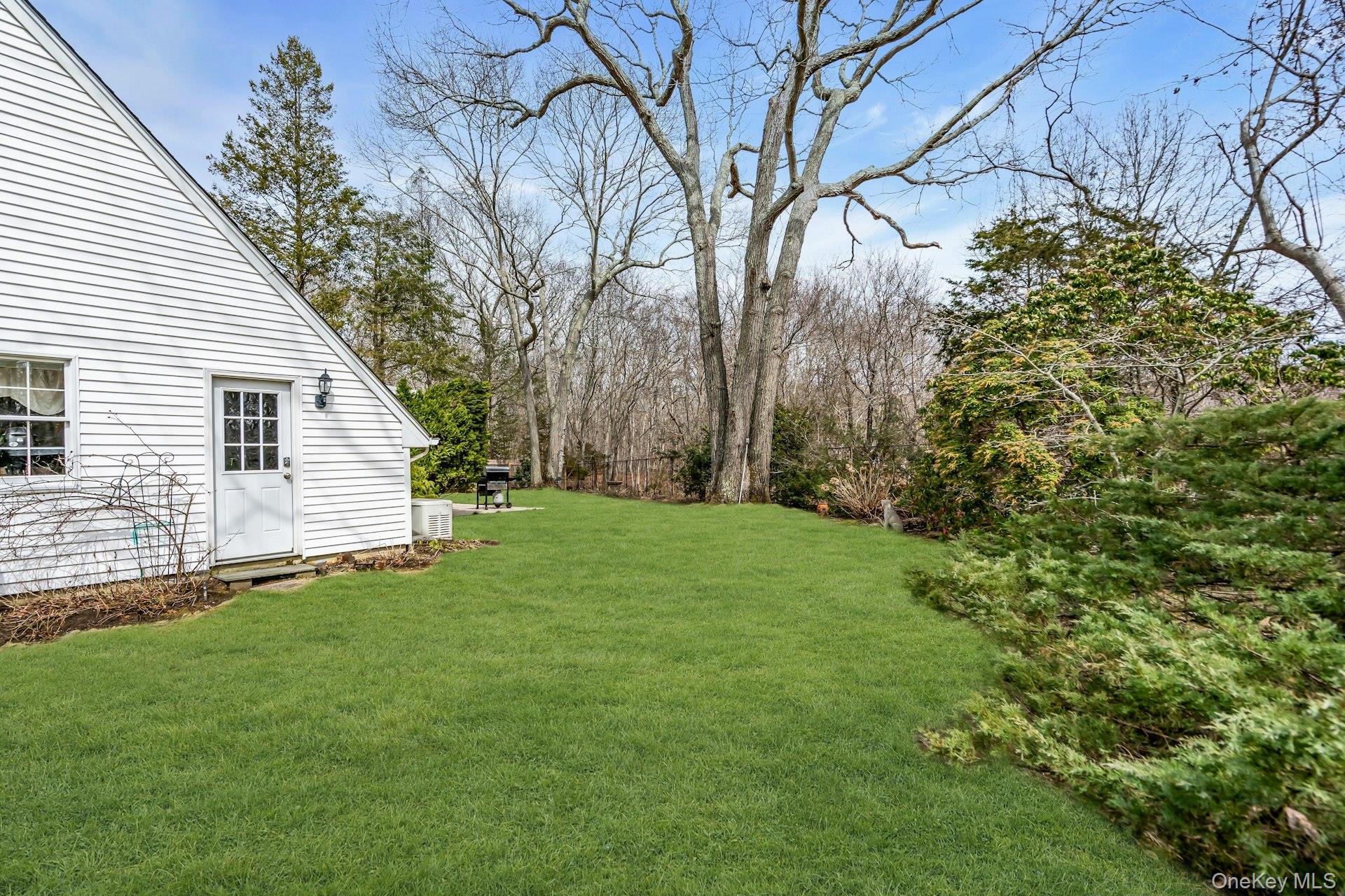 5845 North Bayview Road Southold, NY 11971 - Photo 21 of 26 Side of structure featuring side yard with plenty of space for a pool and door to garage