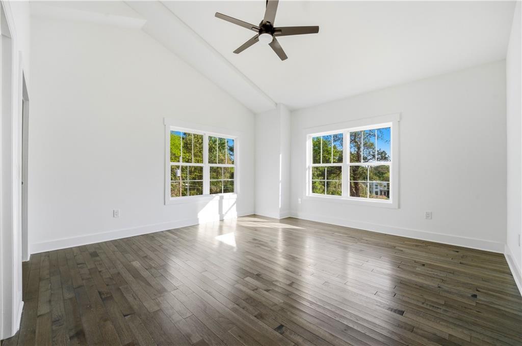 358 St Johns Avenue Southwest Atlanta, GA 30315 - Photo 21 of 35 an empty room with wooden floor ceiling fan and windows