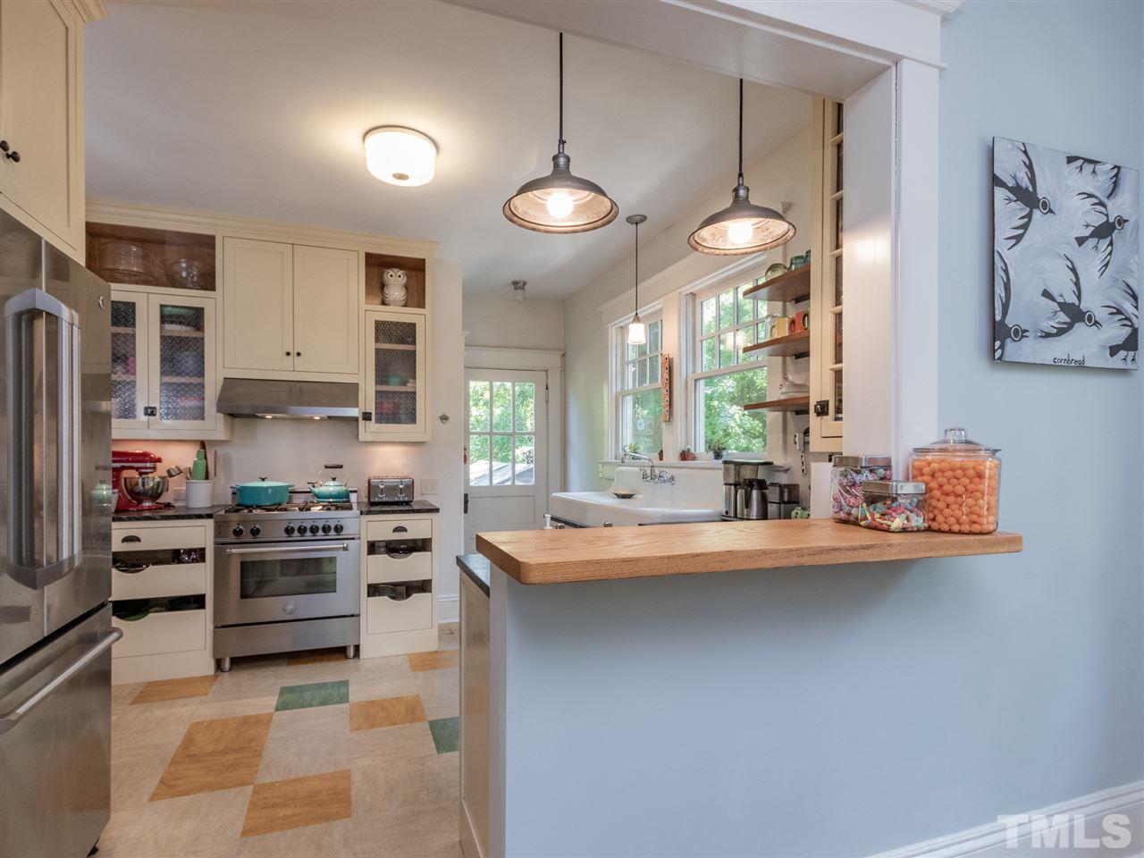 517 Washington Street Raleigh, NC 27605 - Photo 13 of 30 a kitchen with stainless steel appliances granite countertop a stove and a sink