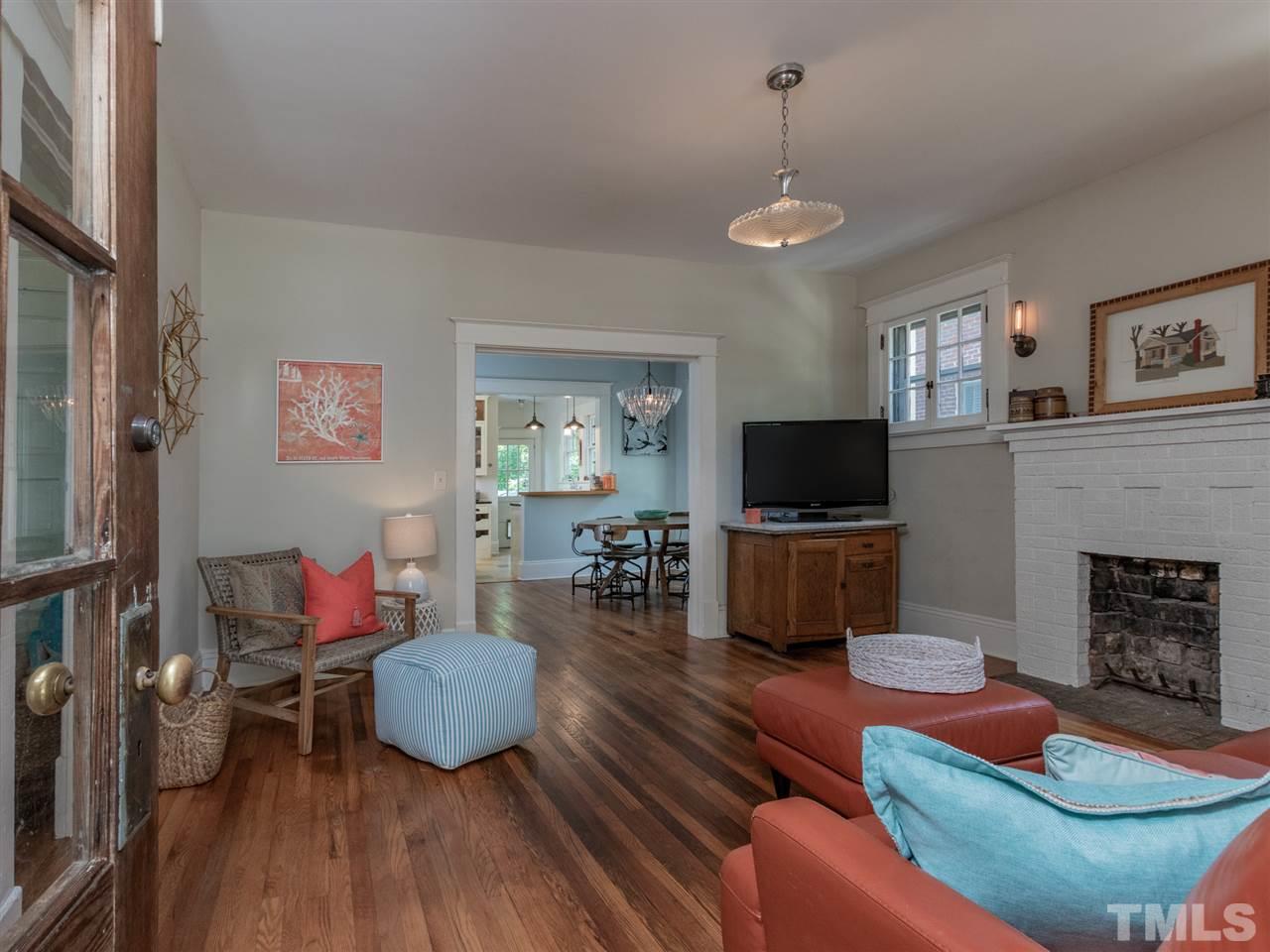517 Washington Street Raleigh, NC 27605 - Photo 6 of 30 a living room with furniture a flat screen tv and a fireplace