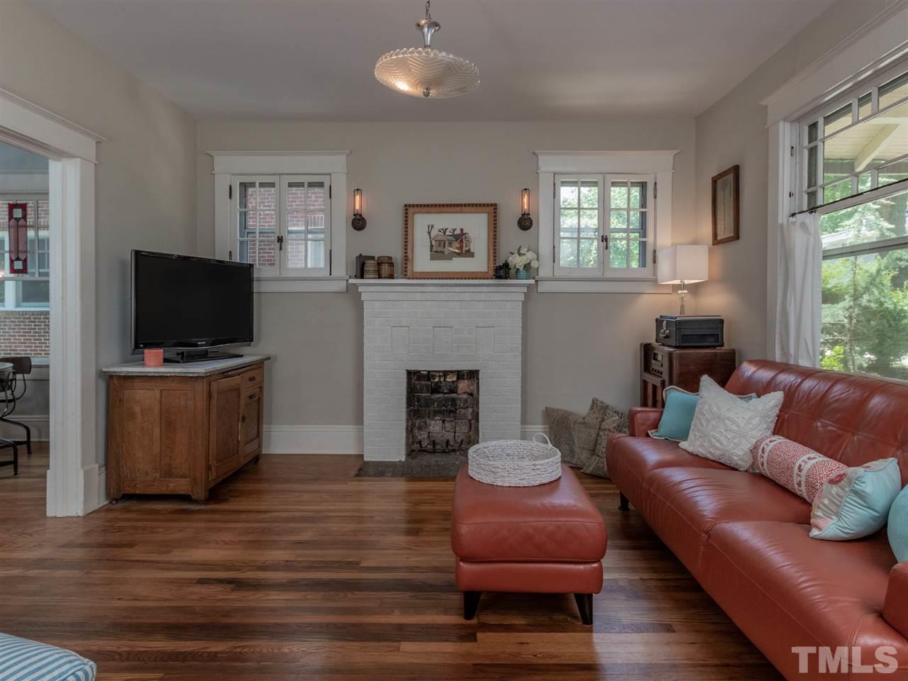 517 Washington Street Raleigh, NC 27605 - Photo 7 of 30 a living room with furniture a fireplace and a flat screen tv
