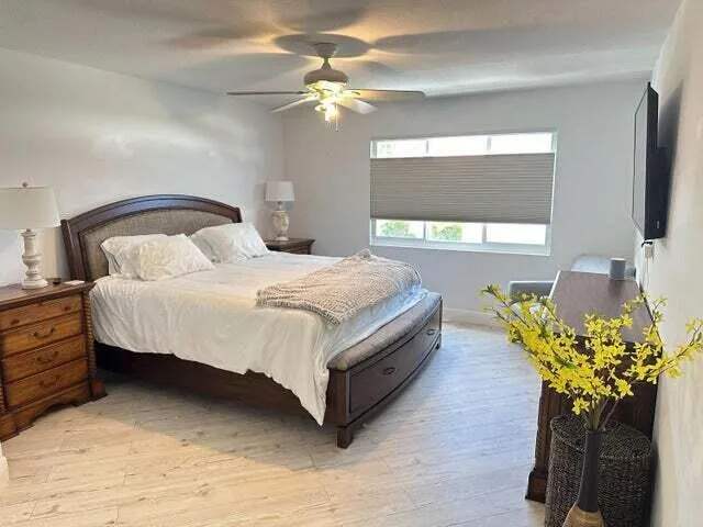 a bedroom with a bed potted plant on dresser and a chandelier