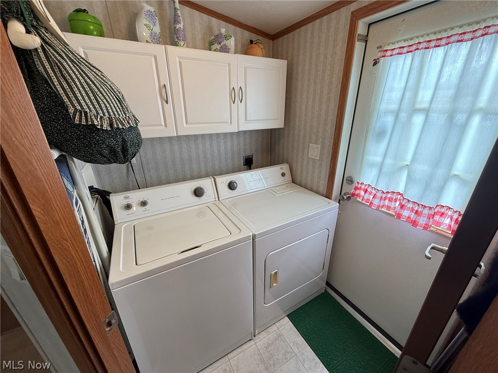 2933 Rabbit Drive Dennison, OH 44621 - Photo 13 of 28 Laundry area featuring wallpapered walls, cabinet space, washing machine and dryer, and crown molding