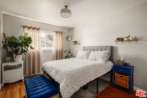 a bedroom with a bed and a potted plant