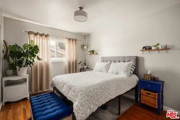 a bedroom with a bed and a potted plant