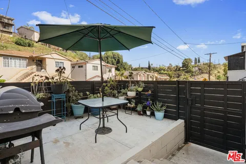 a view of a patio with table and chairs under an umbrella
