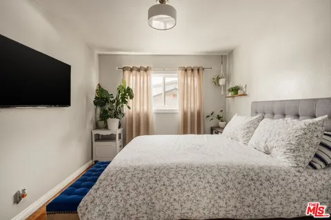 a bedroom with a bed and a flat screen tv