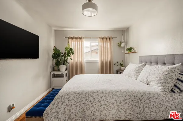 a bedroom with a bed and a flat screen tv