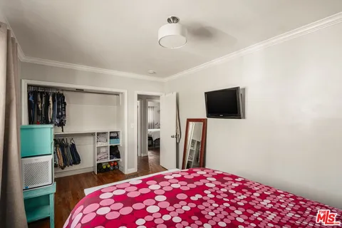 a bedroom with a bed and a flat screen tv