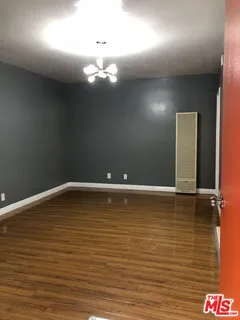 a bedroom with a bed and a lamp on dresser