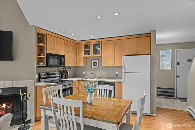 a kitchen with stainless steel appliances granite countertop a refrigerator a stove top oven a sink dishwasher and wooden cabinets