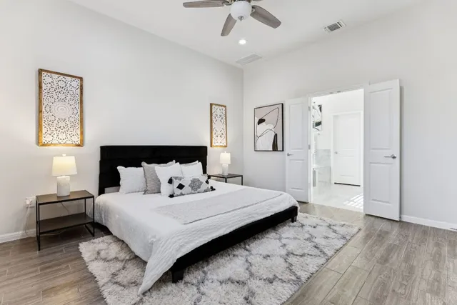 a bedroom with a large bed and a ceiling fan
