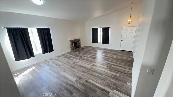 a view of a livingroom with wooden floor and a window
