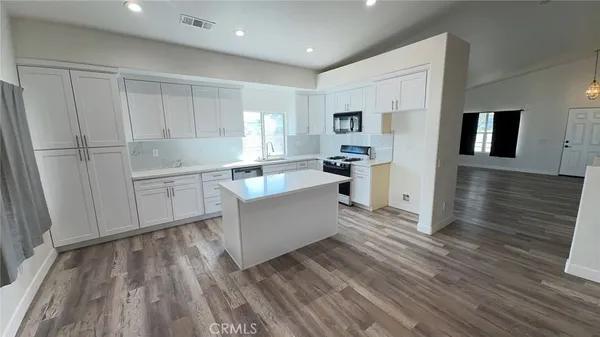 a kitchen with white cabinets and appliances