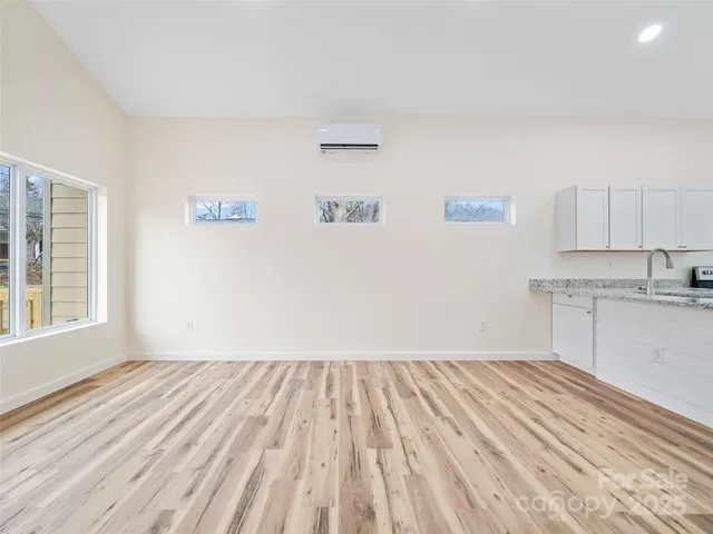 a view of a kitchen with wooden floor and a sink