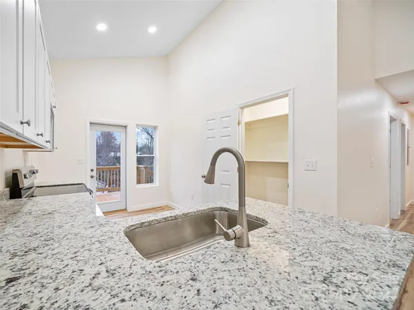 a kitchen with granite countertop a sink and a stove top oven