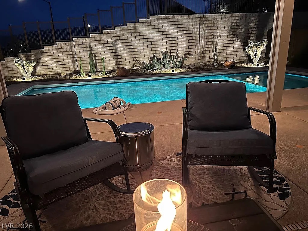 1304 Cottage Ridge Mesquite, NV 89034 - Photo 32 of 52 An inviting outdoor oasis awaits with a shimmering pool and desert landscaping, perfect for tranquil evenings.