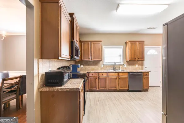 a kitchen with stainless steel appliances granite countertop a stove a sink and a microwave