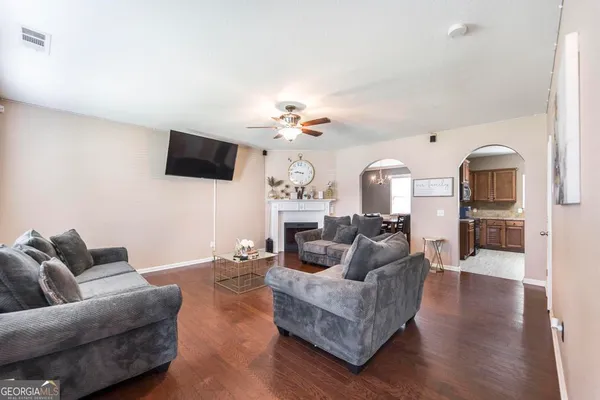 a living room with furniture a flat screen tv and kitchen view