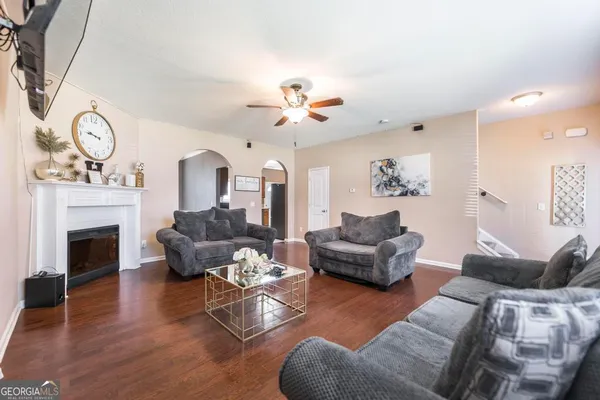 a living room with furniture a fireplace and a chandelier