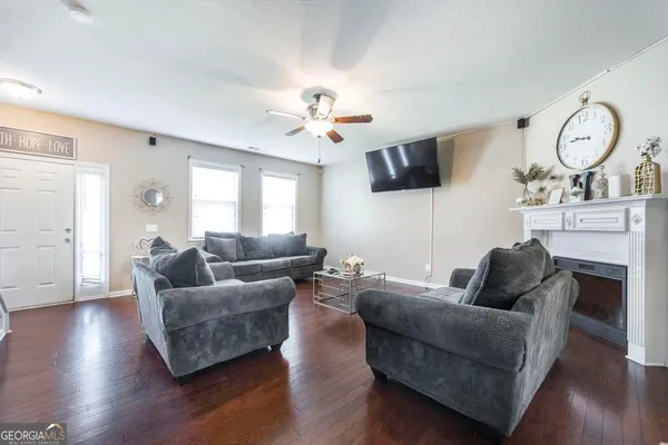 a living room with furniture a large window and a fireplace