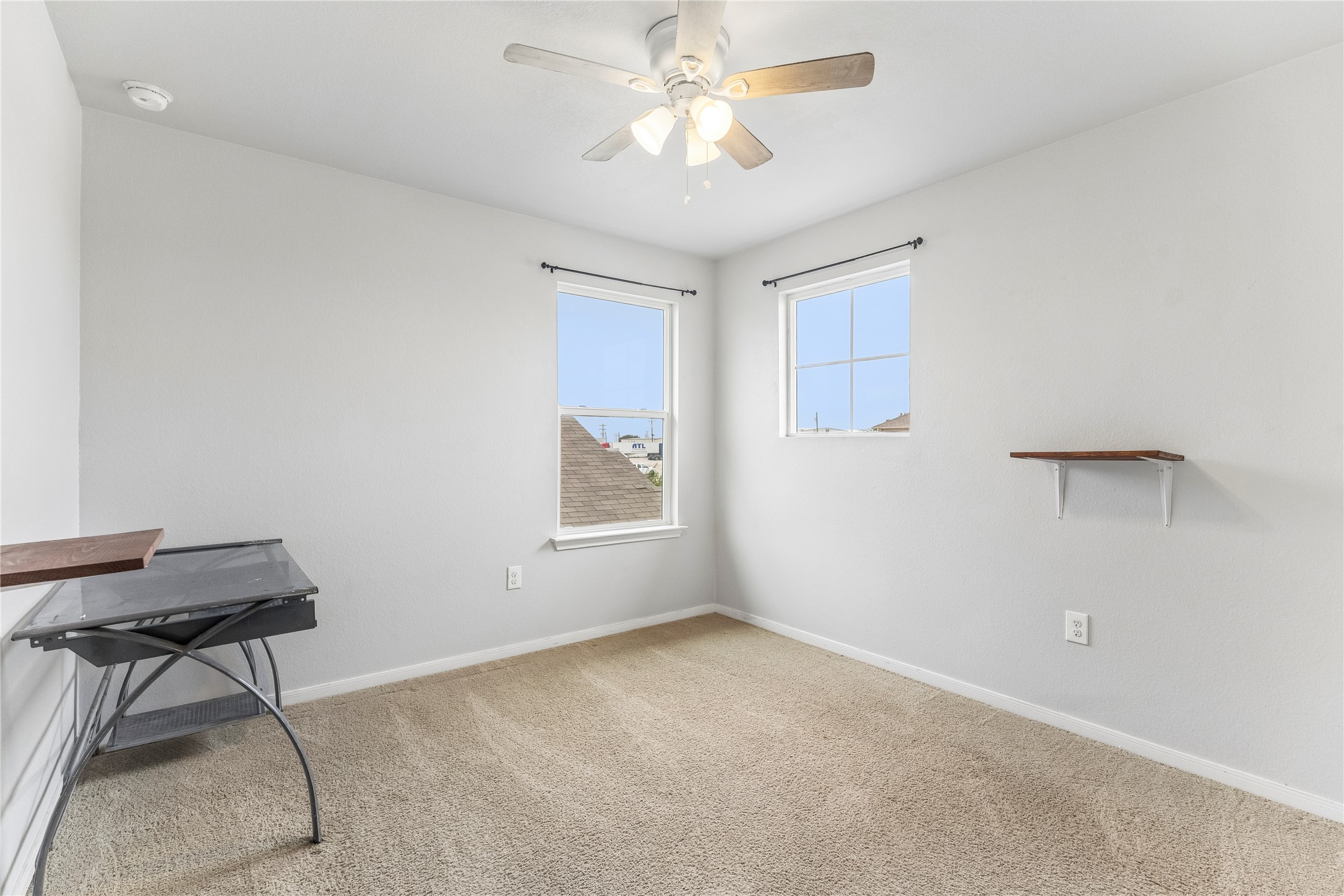14409 Estuary Road Manor, TX 78653 - Photo 18 of 24 Carpeted room featuring two windows, a ceiling fan with integrated lighting, and neutral wall tones
