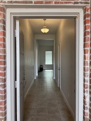a view of a hallway with wooden floor and a cabinet