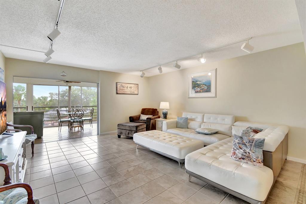 9220 Southwest 14th Street, Unit 3304 Boca Raton, FL 33428 - Photo 20 of 46 a living room with furniture and a dining table with kitchen view