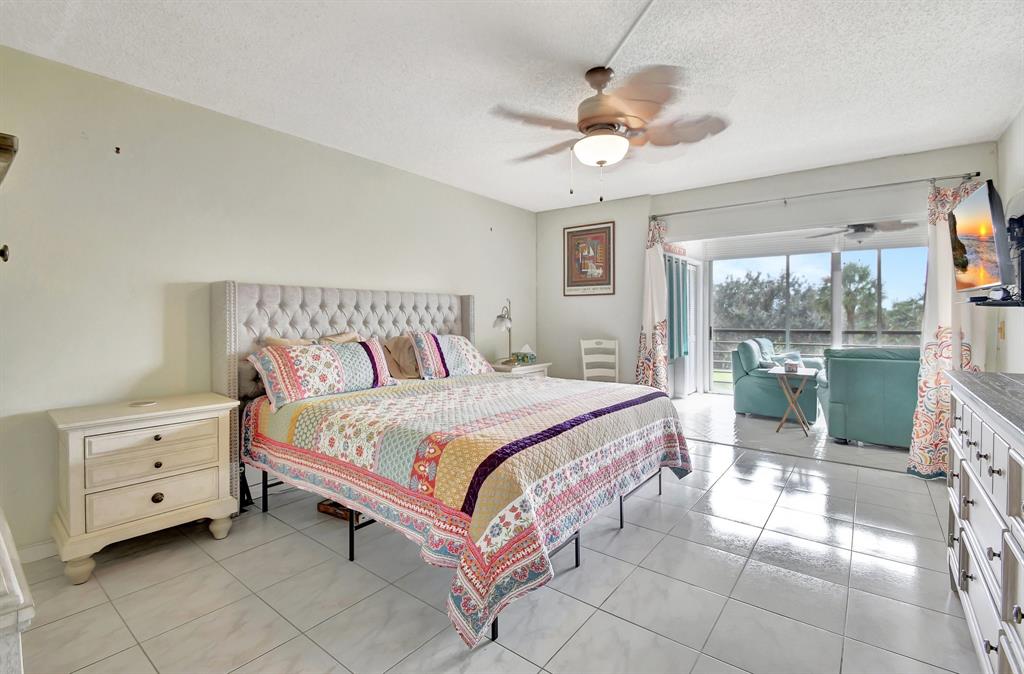 9220 Southwest 14th Street, Unit 3304 Boca Raton, FL 33428 - Photo 23 of 46 a bedroom with a bed and a chandelier