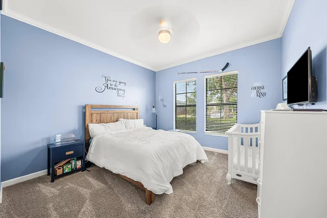 a bedroom with a bed and a flat tv screen on wall