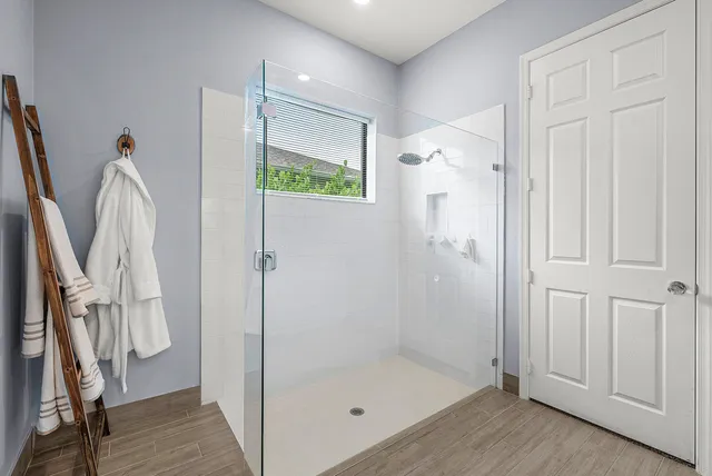 a bathroom with a glass shower door and a window