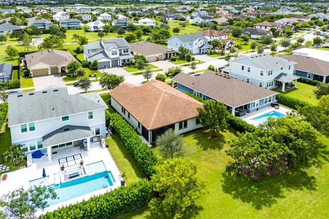 an aerial view of residential houses with outdoor space and trees all around