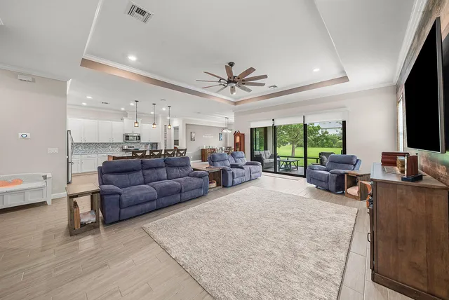 a living room with furniture a flat screen tv and a large window