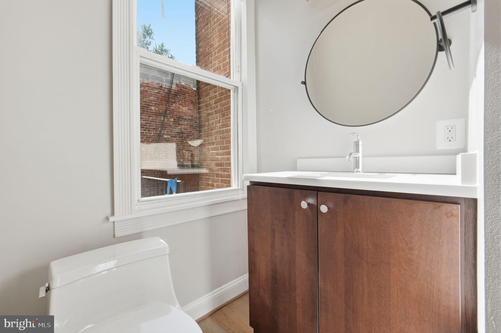 706 12th Street Northeast Washington, DC 20002 - Photo 15 of 49 a bathroom with a sink a toilet and a mirror
