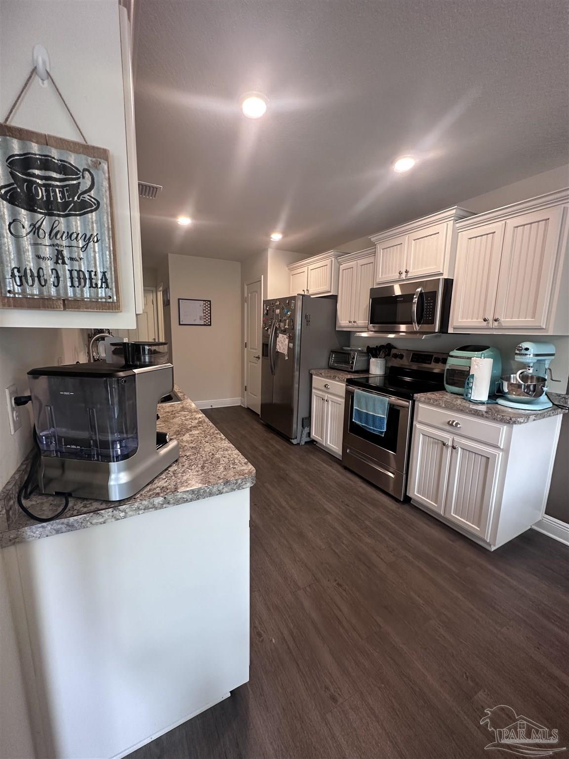 5217 Saufley Field Road Pensacola, FL 32526 - Photo 10 of 26 a kitchen with stainless steel appliances granite countertop a stove a sink and a microwave