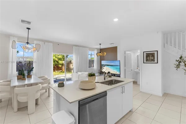 a kitchen with a sink and chairs