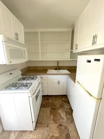 a kitchen with a stove a sink and a refrigerator