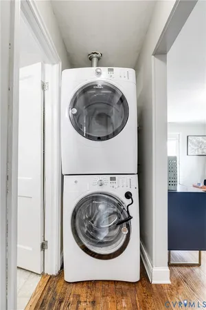 a utility room with wooden floor washer and dryer